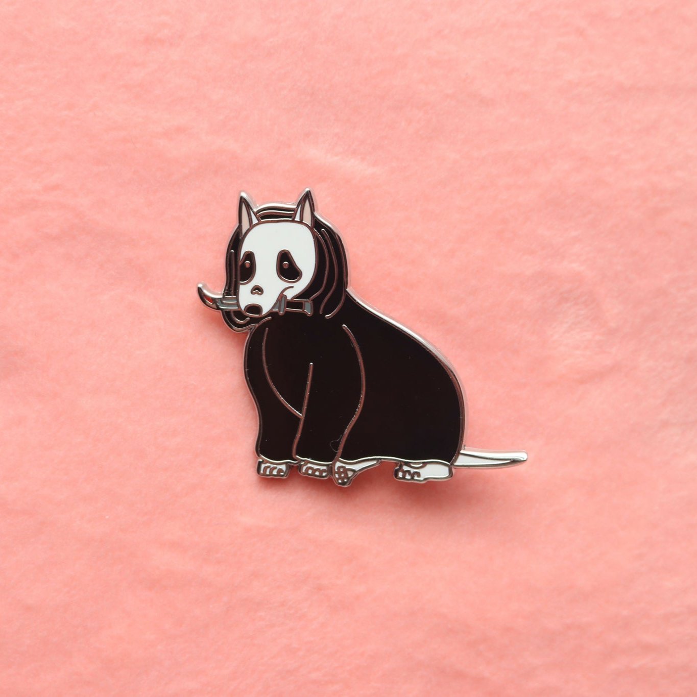 Enamel Pin of a Bull Terrier holding a bloody dagger and wearing a black cloak.