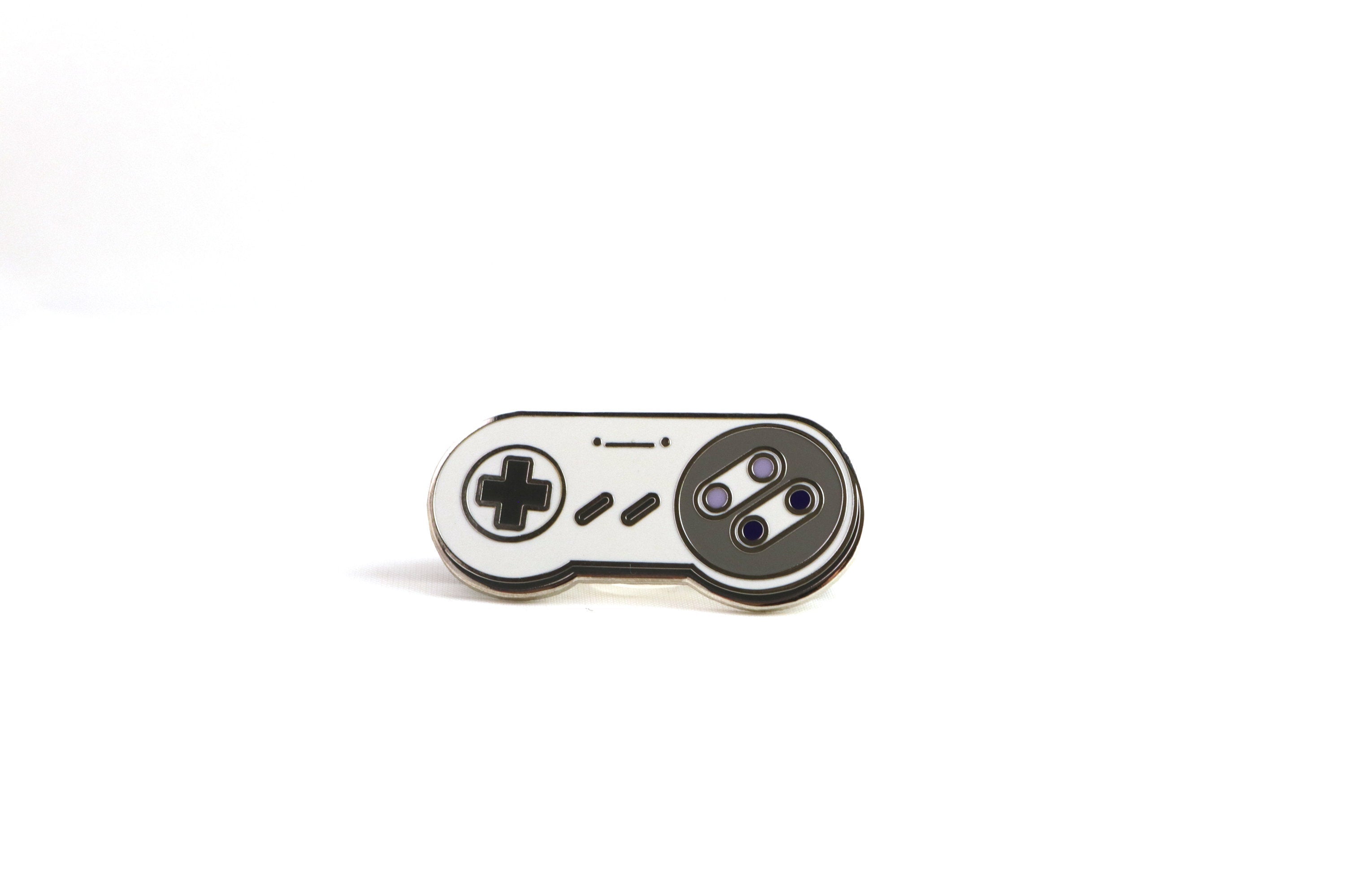 Gray SNES Controller Hard Enamel Pin on White Background