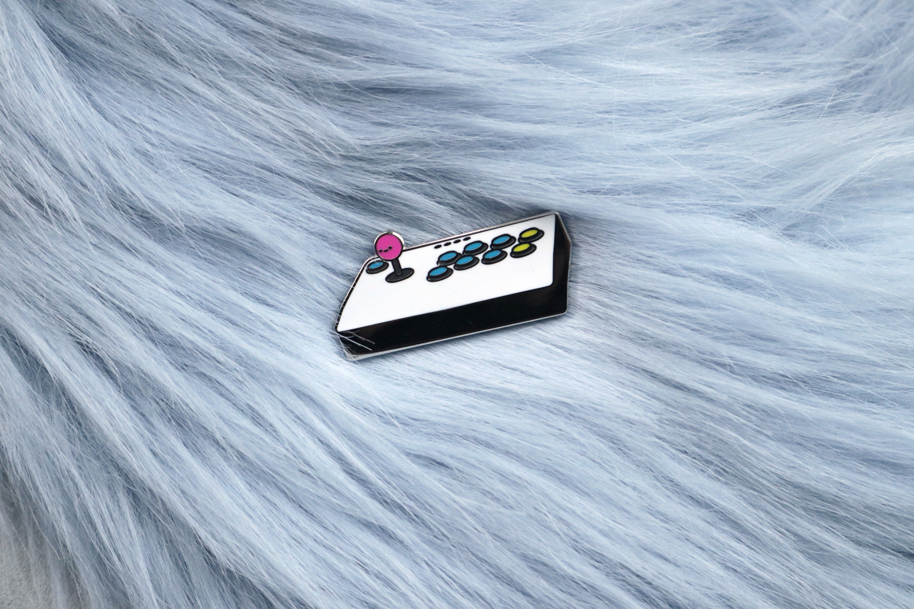 White Fight Stick with Pink Balltop Hard Enamel Pin on Blue Fur Background