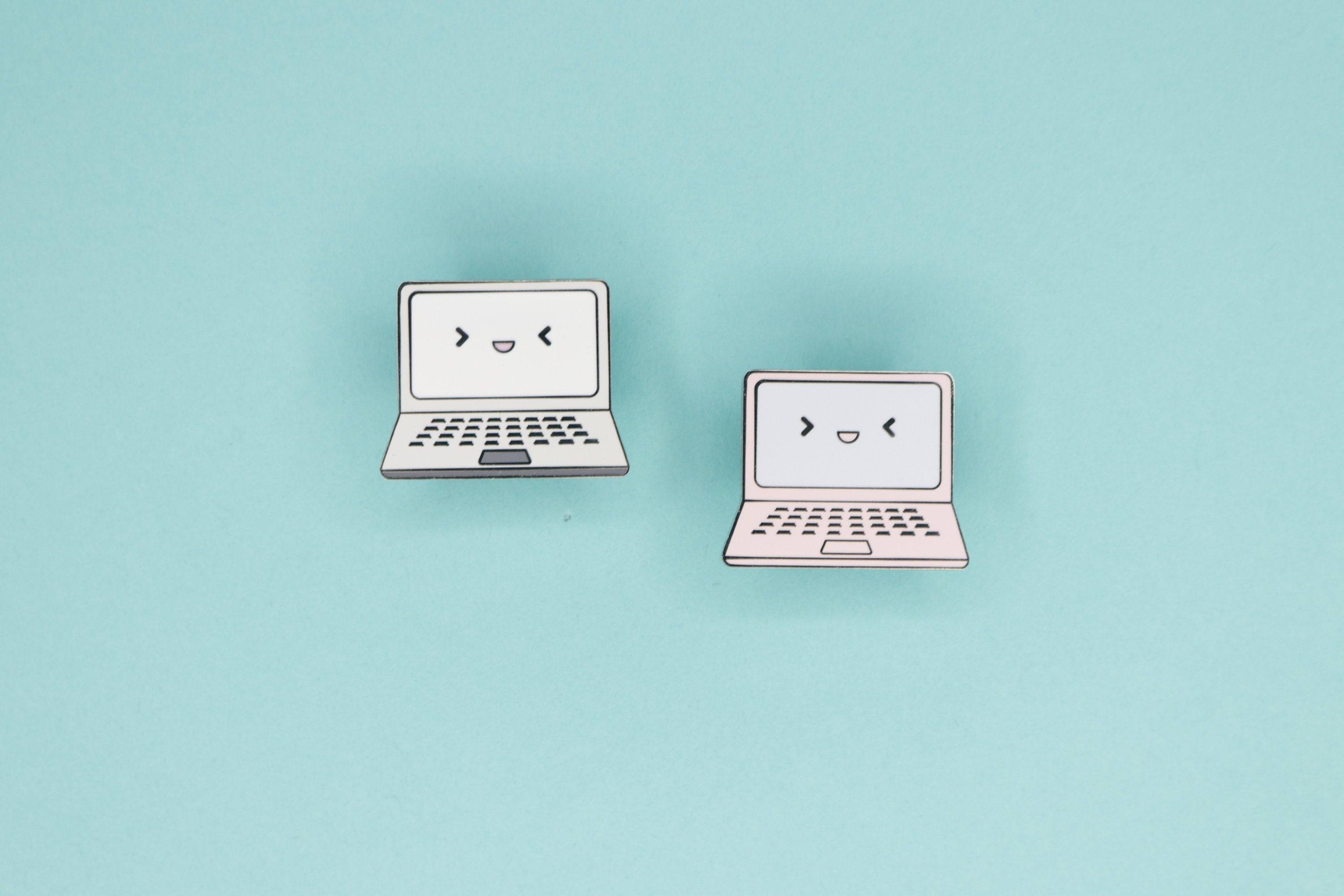 Two Laptop Hard Enamel Pins on Teal Background